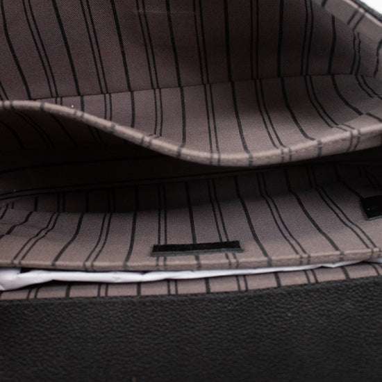 Close-up of the interior of a bag with a dark gray and black pinstripe pattern lining and a black textured exterior.