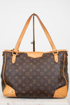 A Louis Vuitton monogram coated canvas shoulder bag with tan leather trim and handles, displayed on a stand against a light gray background.