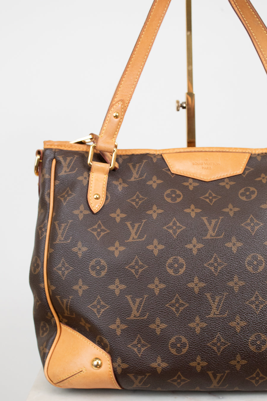 Louis Vuitton monogram coated canvas shoulder bag with tan leather trim and gold-tone hardware, shown against a plain light background.