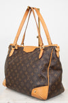 Louis Vuitton monogram canvas shoulder bag with tan leather trim and handles, displayed on a white background.
