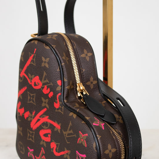 Designer handbag with monogram pattern and colorful text on a white background