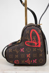 Heart-shaped handbag with monogram pattern and red heart design on a white background