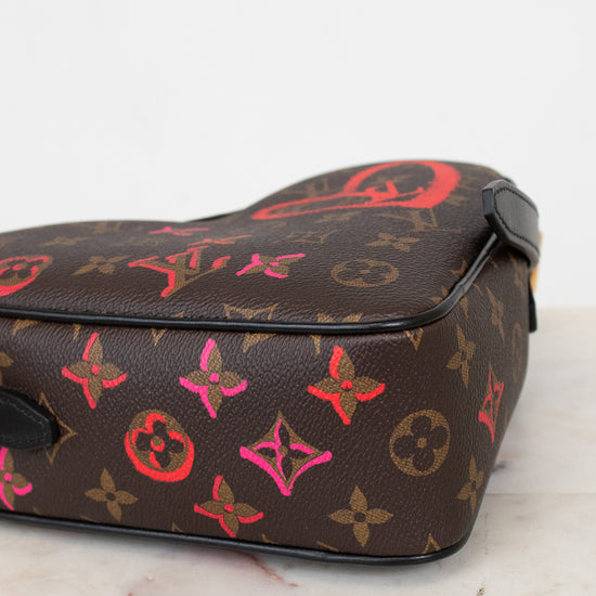 Designer handbag with colorful monogram pattern on a marble surface