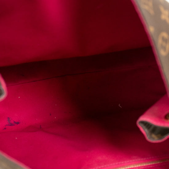 Close-up of a pink interior of handbag with a gold logo patch on a white background