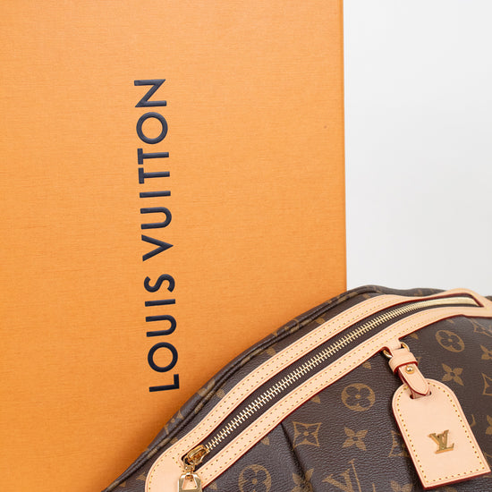 Louis Vuitton monogram bum-bag in brown coated canvas with beige leather trim and gold-tone hardware, shown in front of an orange Louis Vuitton box on a white surface.