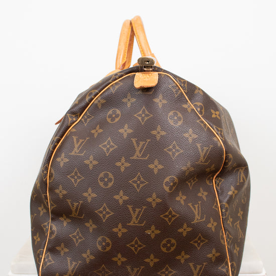 Side view of monogram coated canvas with leather trim details against a light background