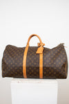 Large monogrammed duffel bag on white stand and against a light background