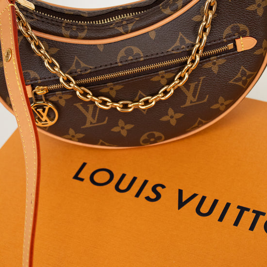 Louis Vuitton handbag with monogram pattern and gold chain on an orange Louis Vuitton box.