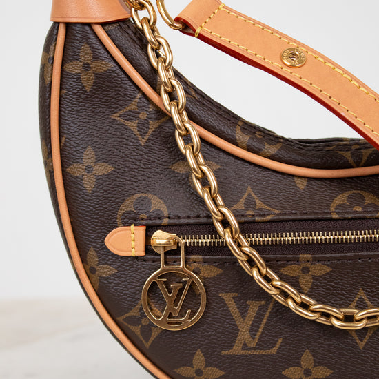 Louis Vuitton handbag with monogram pattern and gold chain on a light background