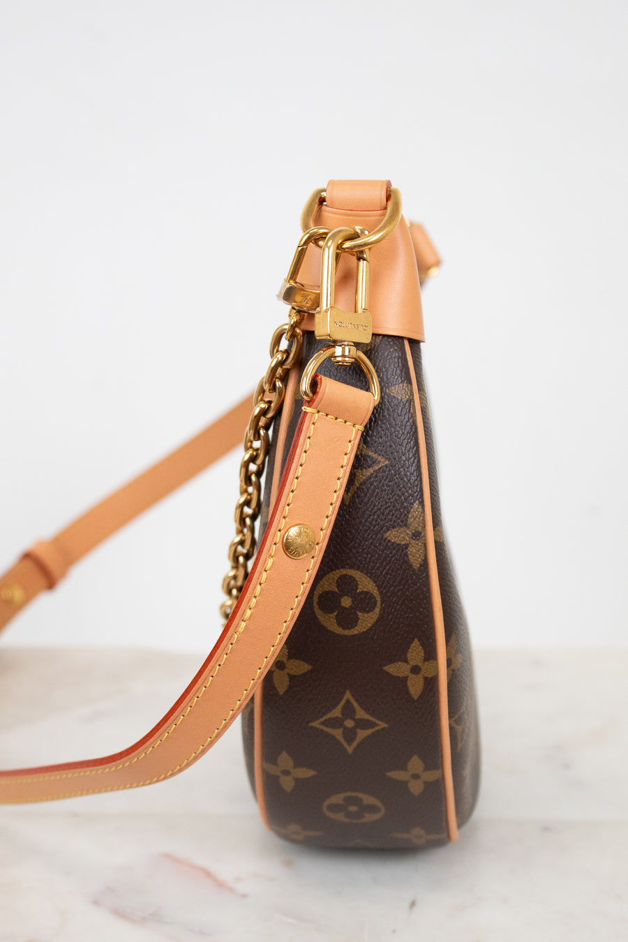 Louis Vuitton handbag with monogram pattern on a light background