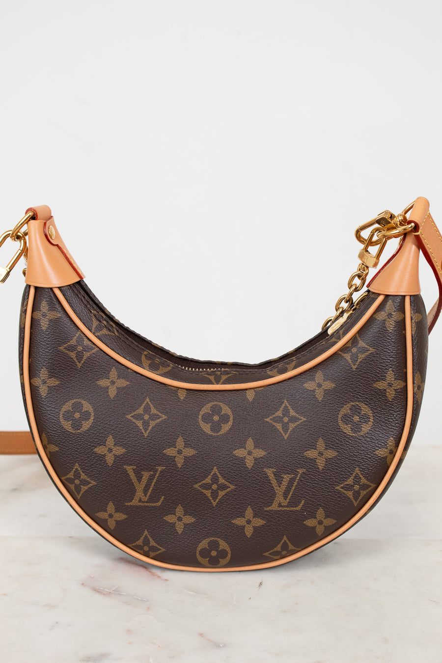 Louis Vuitton handbag with monogram pattern on a white background