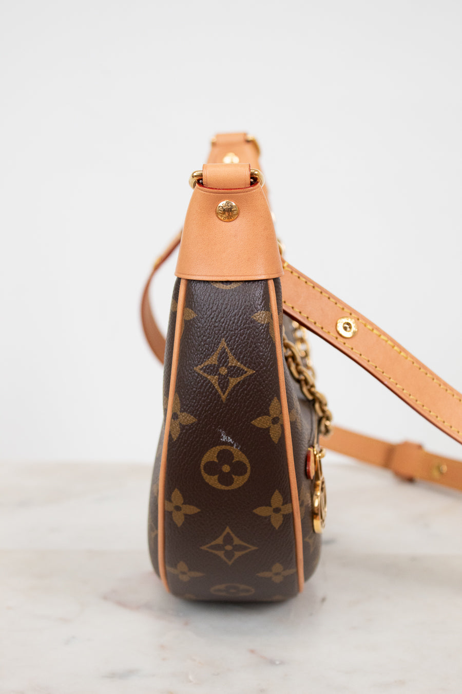 Louis Vuitton handbag with monogram pattern on a marble surface