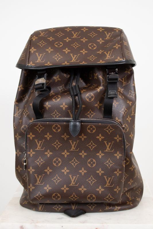 Brown backpack with monogram pattern on a white background
