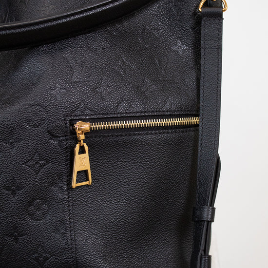 Black leather bag with gold zipper and hardware on a white background