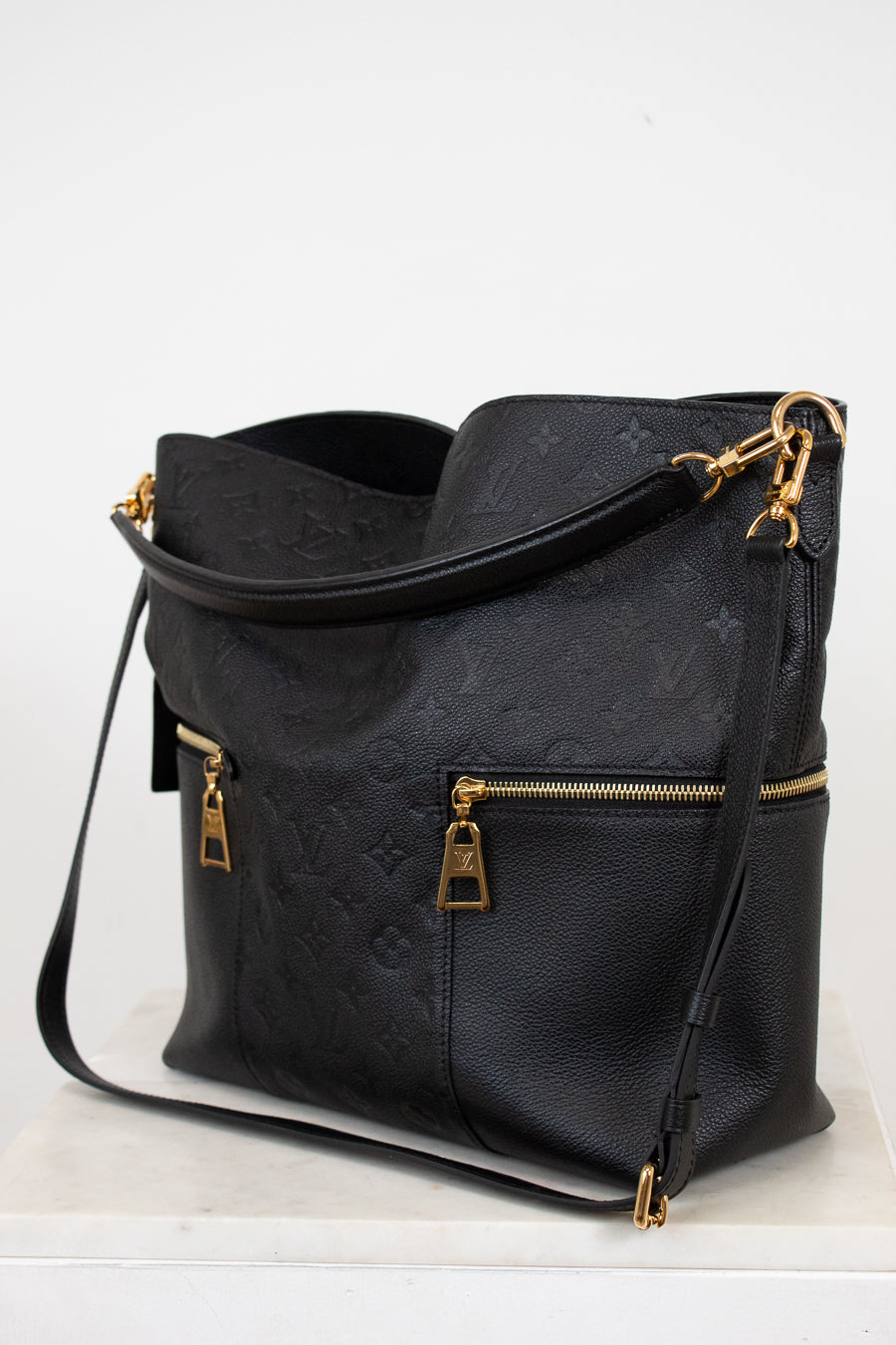 Black handbag with gold accents on a white background