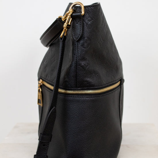Black leather backpack with gold zippers on a white background