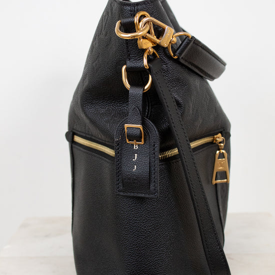 Black leather backpack with gold zippers and hardware on a white background