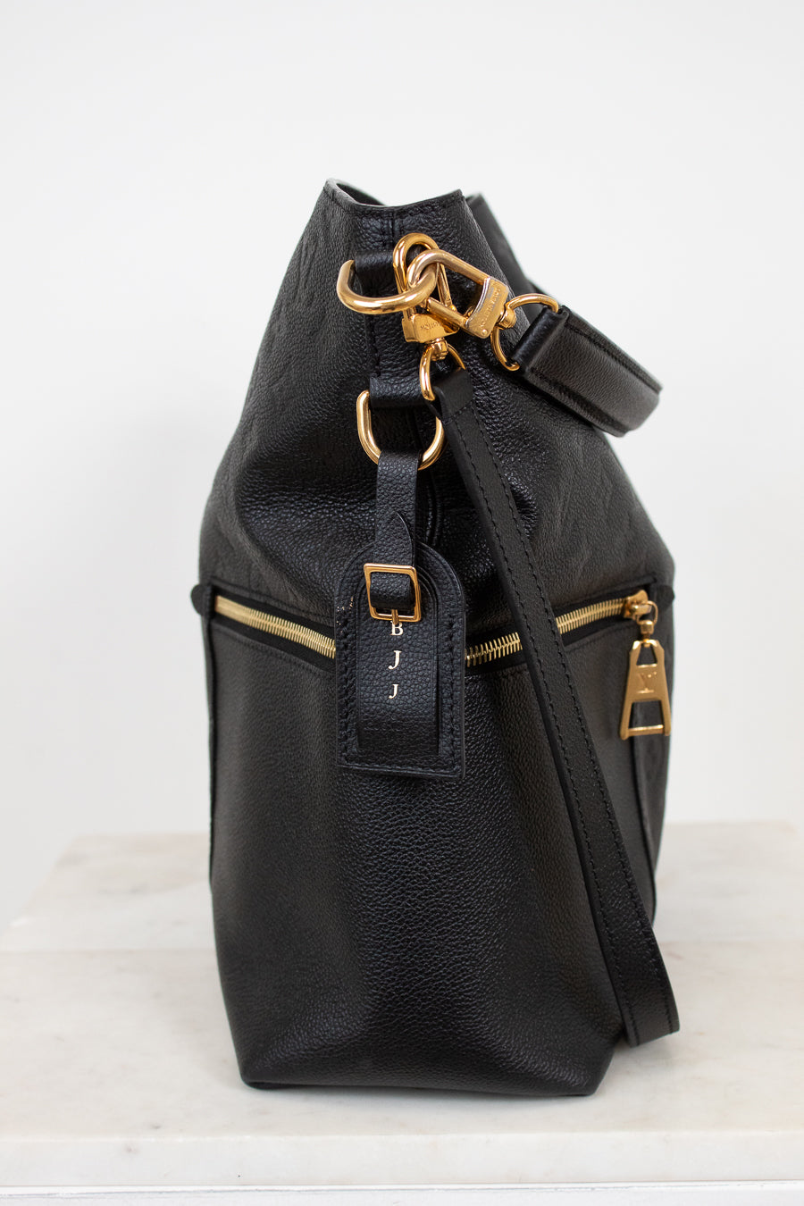 Black leather backpack with gold zippers and hardware on a white background