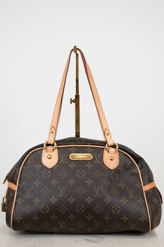 Designer handbag with monogram pattern on a light gray background