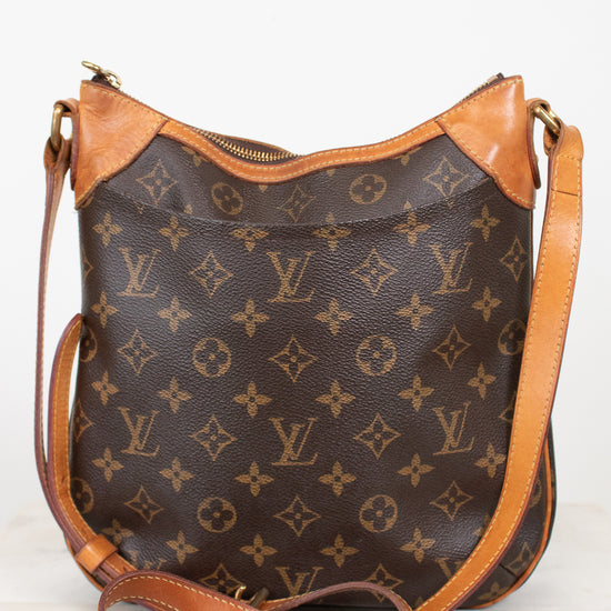 A Louis Vuitton monogram shoulder bag in brown coated canvas with tan leather trim and a matching adjustable shoulder strap, photographed against a plain light background.
