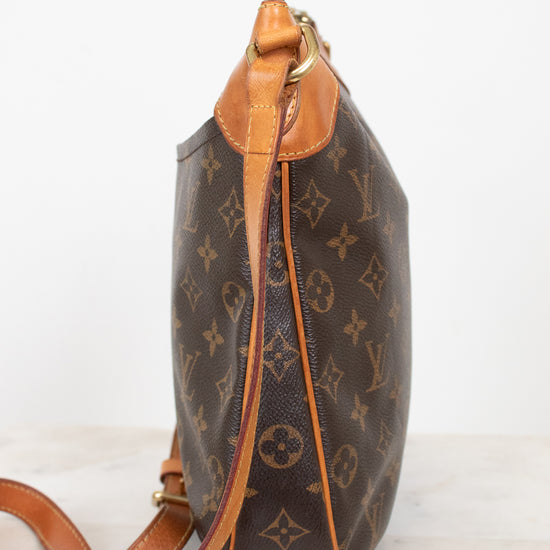 A Louis Vuitton monogram coated canvas shoulder bag shown from a side profile view, featuring the classic brown and tan monogram pattern with a tan leather trim and strap, set against a plain white background.