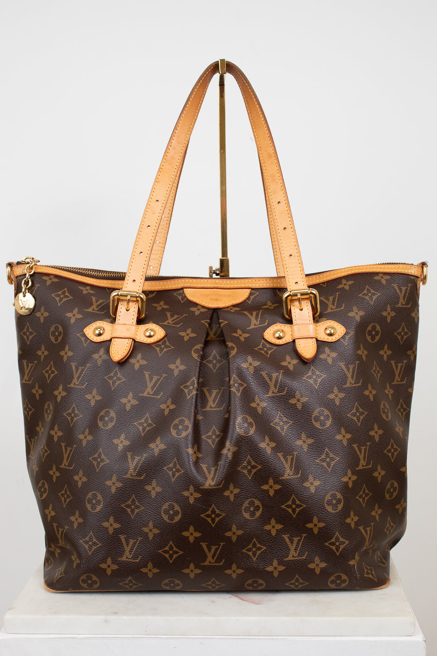 Designer handbag with monogram pattern on a white background