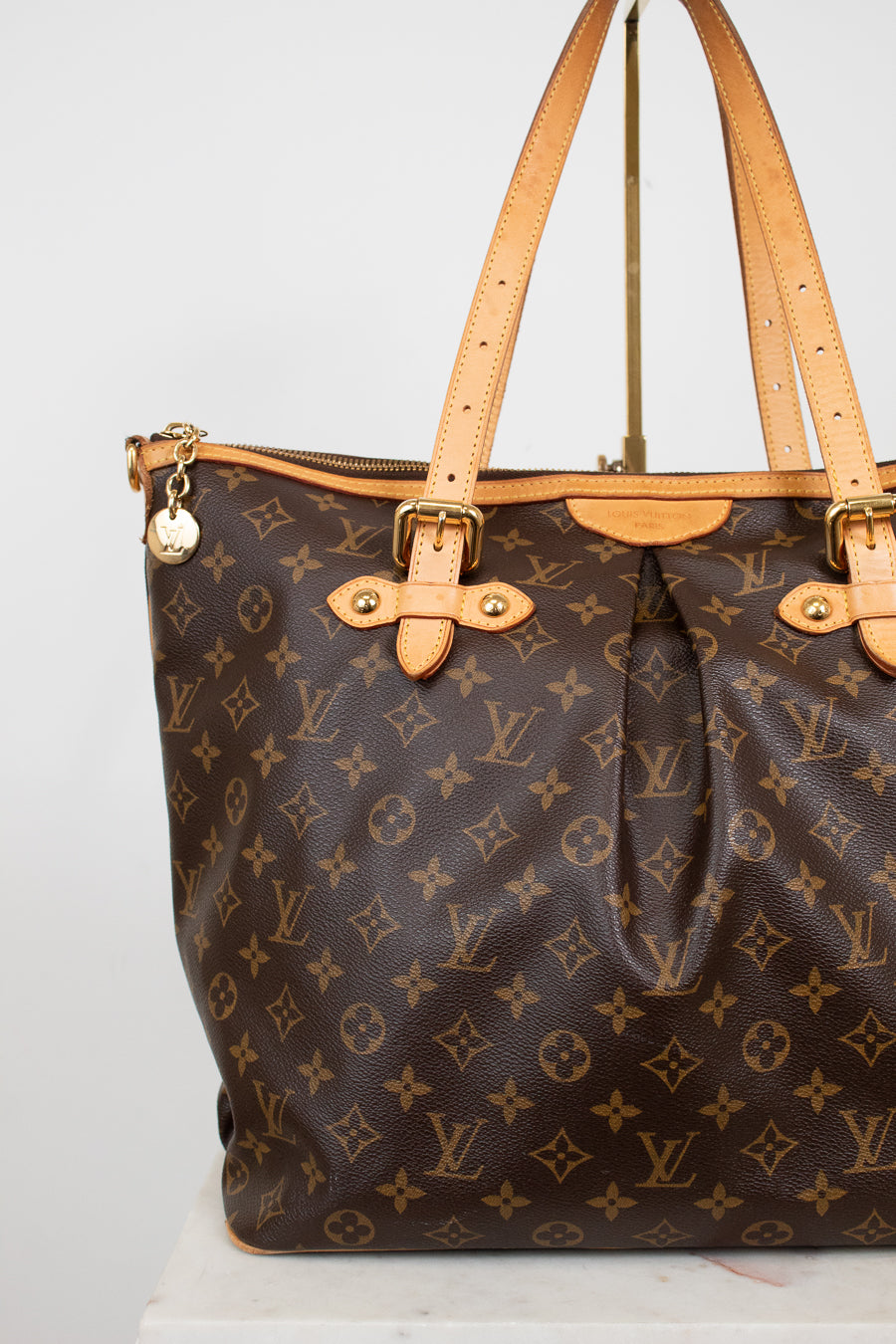 Louis Vuitton handbag with monogram pattern on a white background