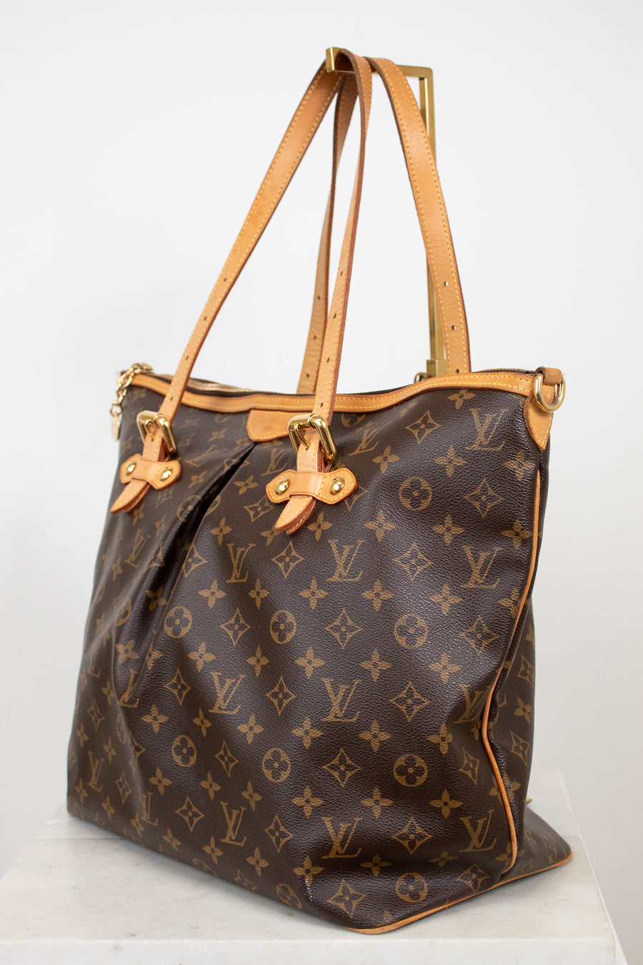 Designer handbag with monogram pattern on a white background