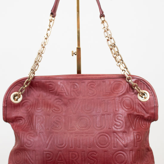 A Louis Vuitton shoulder bag in burgundy embossed leather with a gold-tone chain strap and a top handle, displayed on a white background.