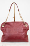 A Louis Vuitton shoulder bag in burgundy embossed leather with a gold-tone chain strap and a top handle, displayed on a white background.