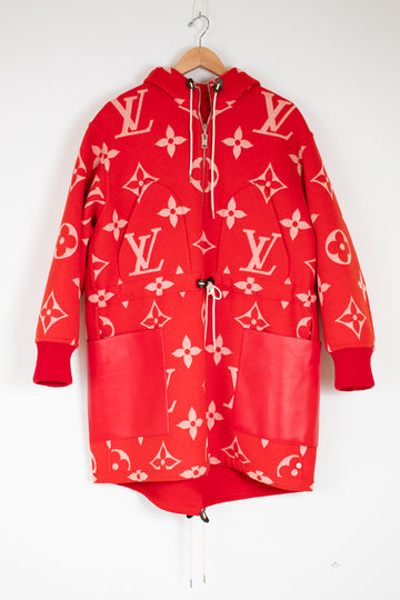 Red hoodie with pink patterns on a hanger against a white background