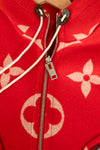 Close up of silver zipper on red coat with pink monogram logo