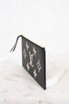 A black textured leather Louis Vuitton pouch featuring the classic beige monogram pattern, shown standing on a white marble surface against a white background.