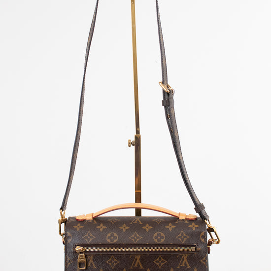 Louis Vuitton monogram shoulder bag in dark brown coated canvas with gold-tone hardware, displayed on a white background with a stand.