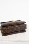 A Louis Vuitton monogram canvas shoulder bag in dark brown with gold-tone hardware, resting on a white marble surface against a white background.
