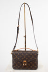 Louis Vuitton monogram canvas shoulder bag with a top handle and adjustable shoulder strap, displayed on a stand against a white background.