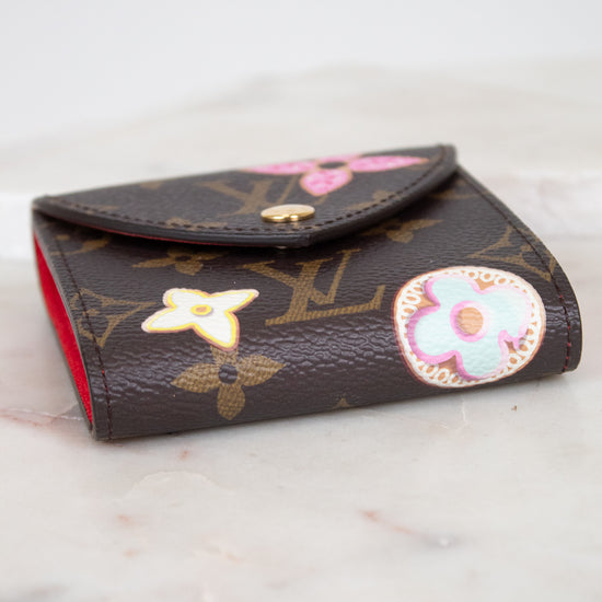 A Louis Vuitton monogram post-it note holder with decorative multi-color details, resting on a light marble surface.