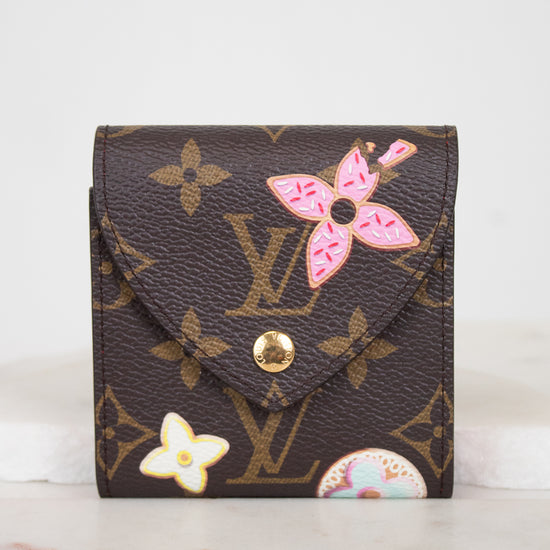 A Louis Vuitton monogram post-it note case with pink and white floral designs, displayed on a light marble surface against a white background.