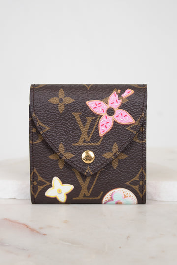 A Louis Vuitton monogram post-it note case with pink and white floral designs, displayed on a light marble surface against a white background.