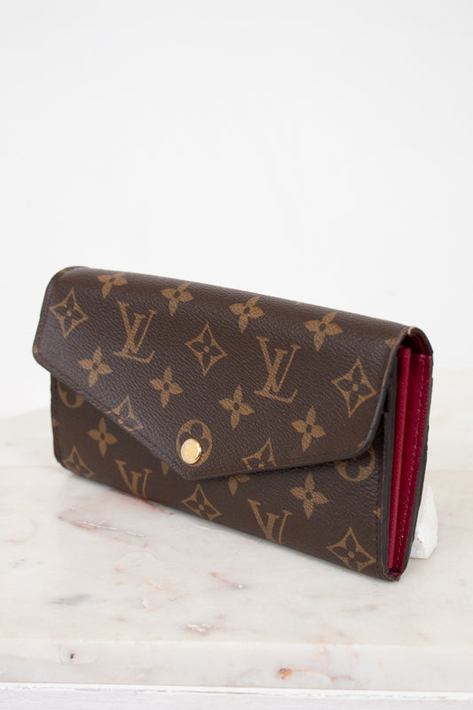 Louis Vuitton wallet with monogram pattern on a marble surface