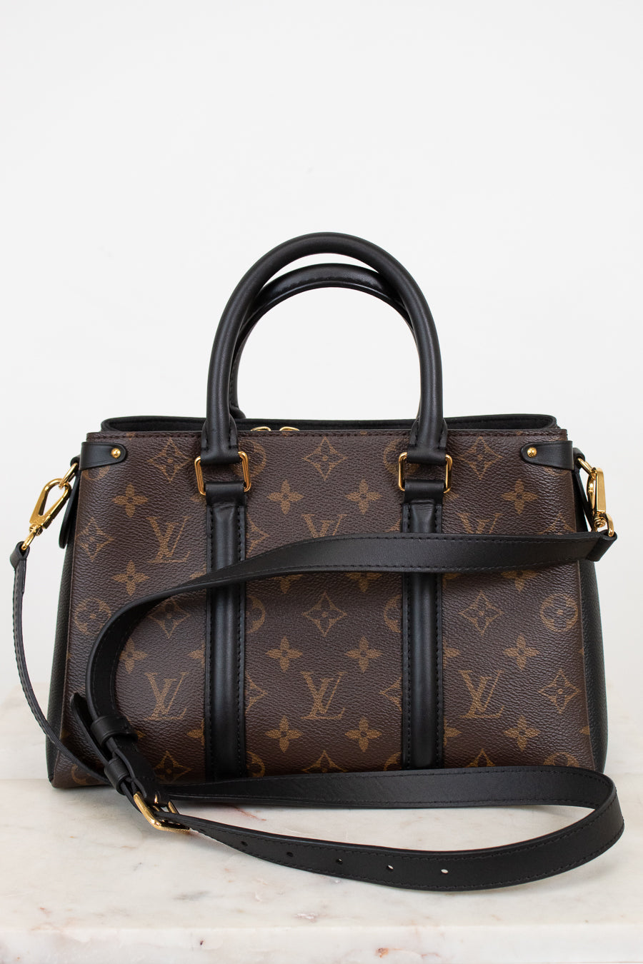 Designer handbag with monogram pattern on a light background