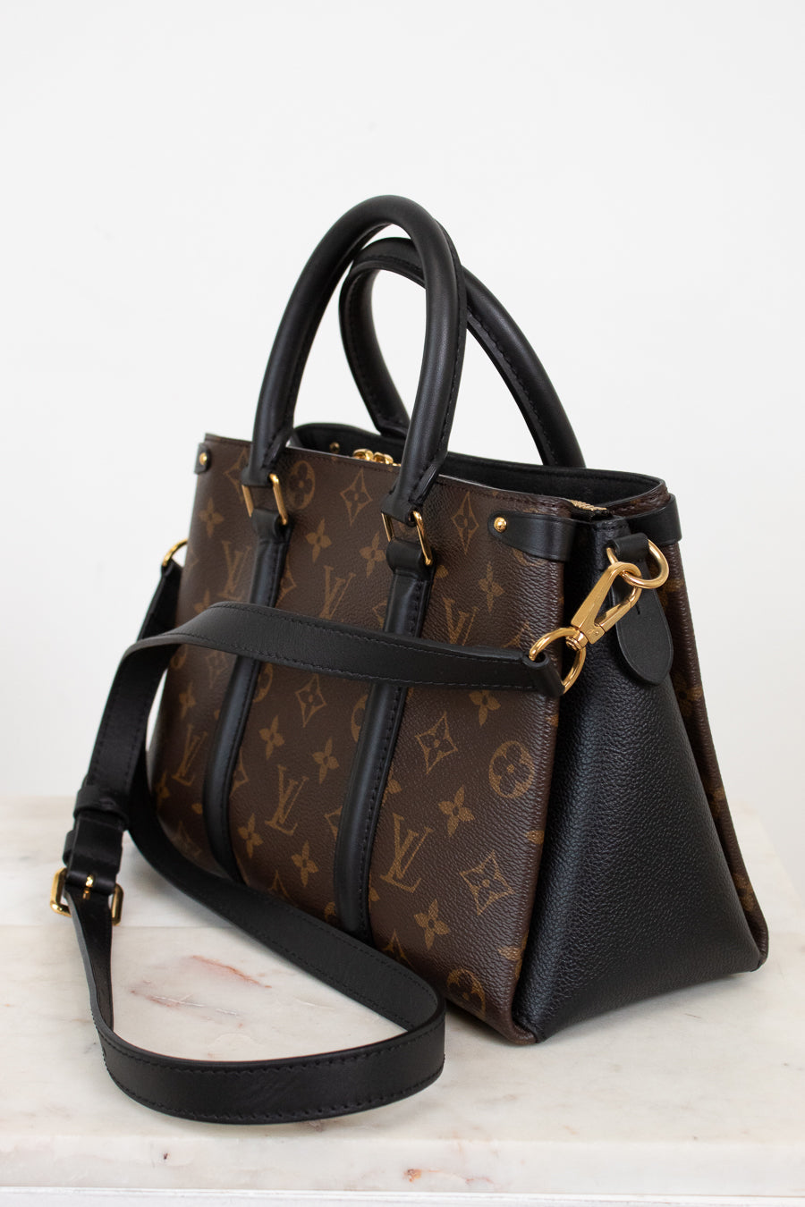 Designer handbag with monogram pattern on a white background