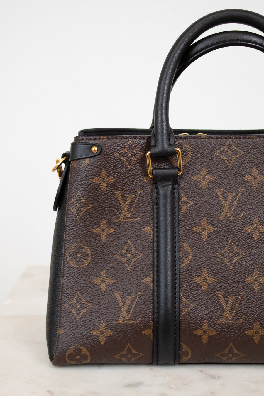 Louis Vuitton handbag with monogram pattern on a light background