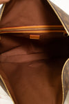 Close-up of the interior of a brown leather bag with gold details and tan logo.