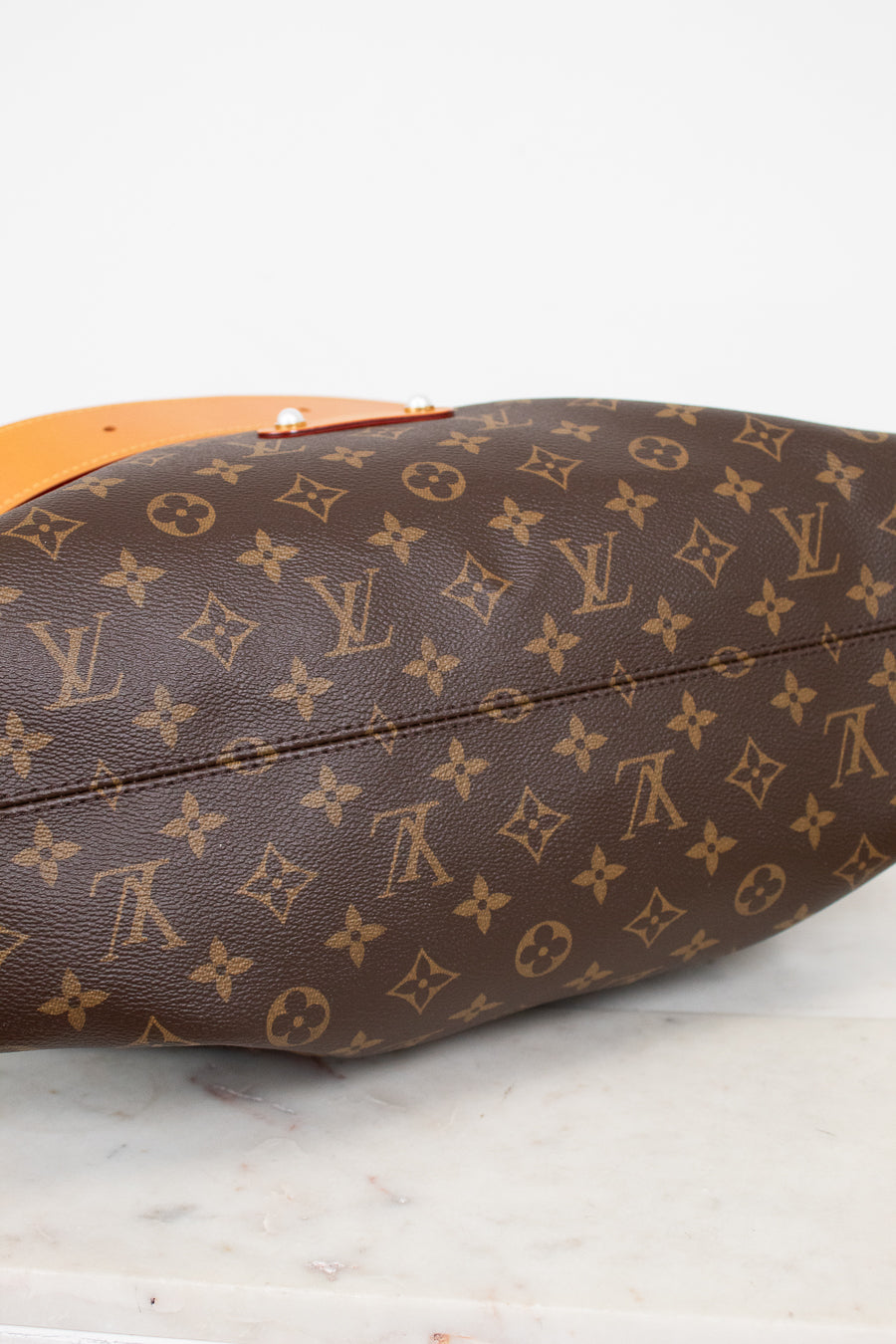Brown Louis Vuitton monogram handbag on a light background