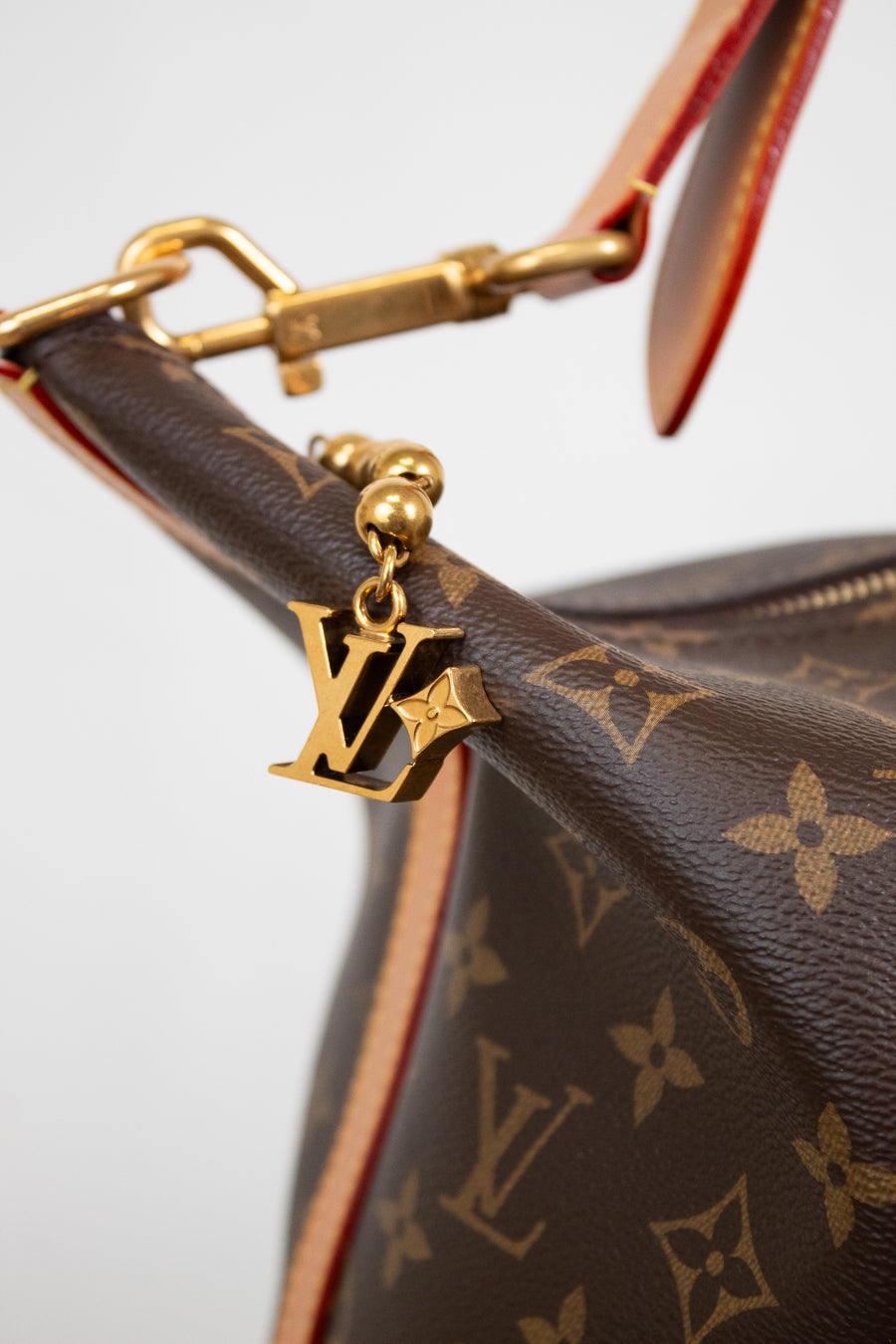 Close-up of a brown Louis Vuitton handbag with gold hardware and monogram pattern.
