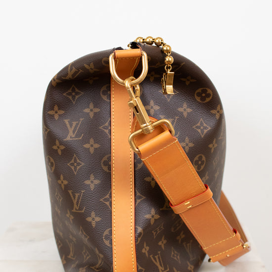 Louis Vuitton handbag with monogram pattern and brown strap on a white background
