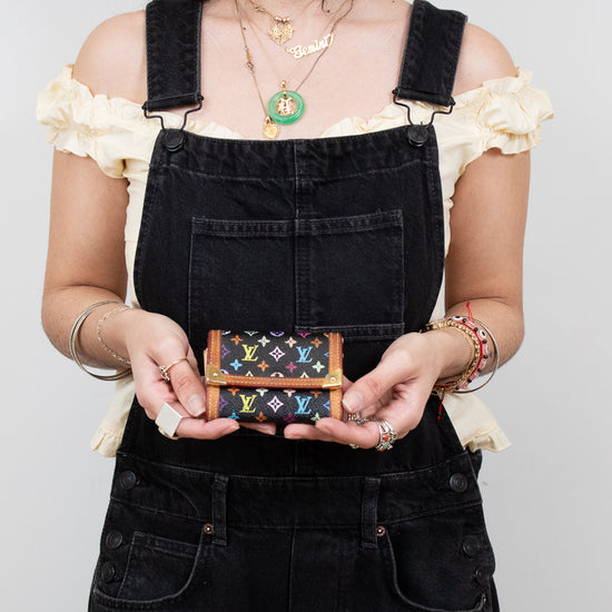 Person holding a colorful wallet with a plain background