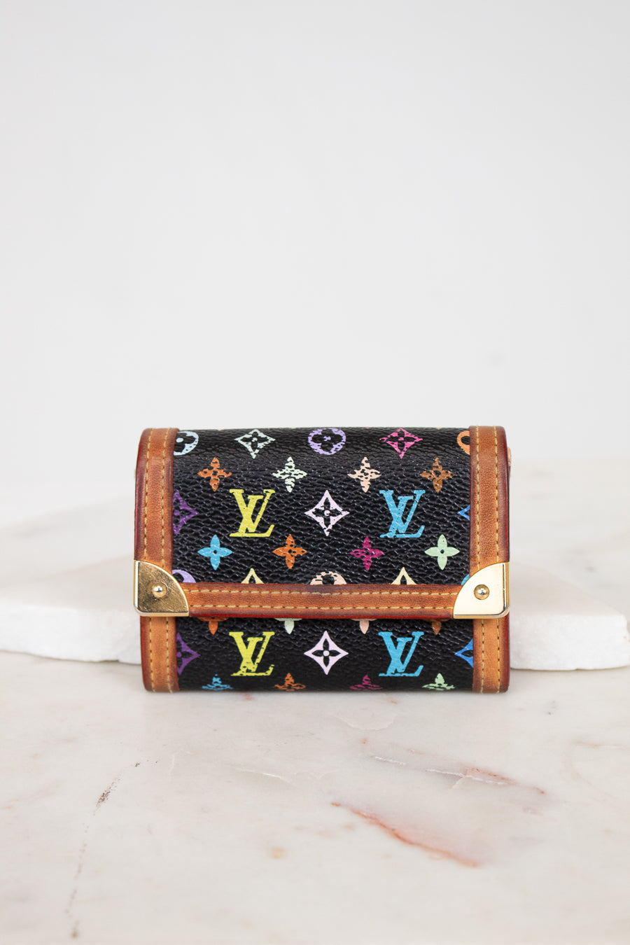 Black wallet with colorful monogram pattern on a white background