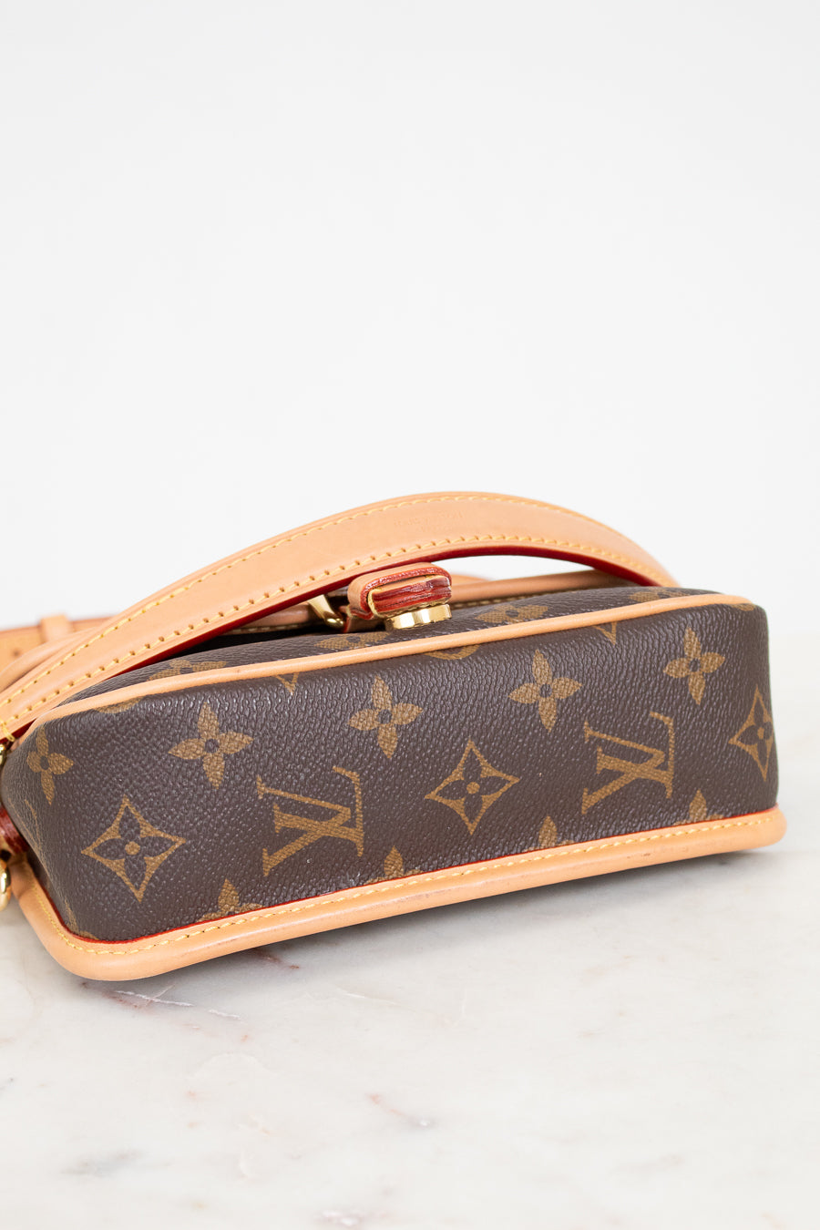 Louis Vuitton handbag with monogram pattern on a light background